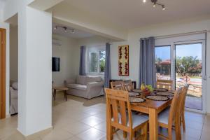 a dining room and living room with a table and chairs at Aloni Grove Retreat in Chania
