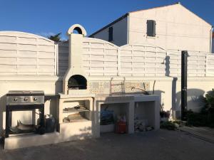 サン・ピエール・ドレロンにあるPort La Cotinière 100m plage et commercesのストーブとオーブンのある白い建物