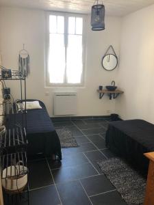 サン・ピエール・ドレロンにあるPort La Cotinière 100m plage et commercesのベッド2台とテーブルと窓のある寝室