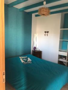 サン・ピエール・ドレロンにあるPort La Cotinière 100m plage et commercesの青い壁のベッドルーム1室 +3枚の写真