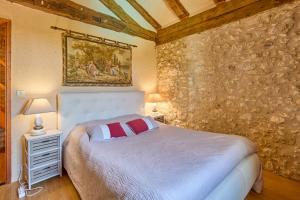 a bedroom with a bed and a stone wall at La Mijotière - maison avec piscine et grand jardin in Thénac +8 photos