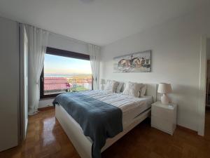 a bedroom with a large bed with a large window at Villa Maris Izola in Izola