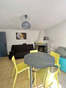 Appartement calme proche du centre في Santa-Reparata-di-Balagna: غرفة معيشة مع طاولة وكراسي صفراء