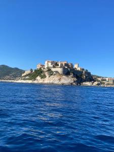 Appartement calme proche du centre في Santa-Reparata-di-Balagna: قلعة في جزيرة وسط الماء +صورتان