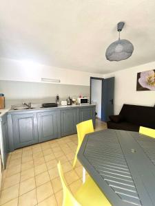 Appartement calme proche du centre في Santa-Reparata-di-Balagna: مطبخ وغرفة معيشة مع طاولة وكراسي صفراء