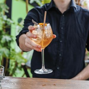 a man is holding a drink in a glass at Collège Hôtel in Lyon