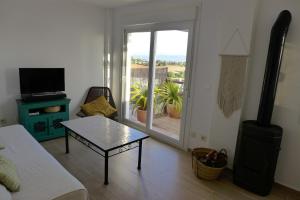 a living room with a coffee table and a balcony at Casa Aurora Vejer in Vejer de la Frontera