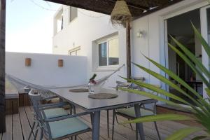 a patio with a table and chairs on a porch at Casa Aurora Vejer in Vejer de la Frontera