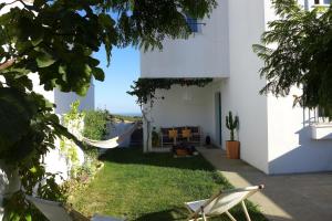 a yard with chairs and a hammock in a house at Casa Aurora Vejer in Vejer de la Frontera