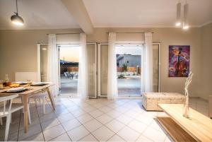 a living room with a table and a dining room at Villa Du Vignoble in Zakynthos Town