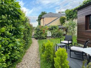 a patio with a table and chairs in a garden at Studio Luxe + jardin et terrasse in Pontoise
