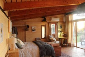 a bedroom with a large bed in a cabin at Freefall Cottage in Haumoana