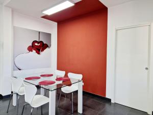 een eetkamer met een glazen tafel en witte stoelen bij Vertigo in Casoria +13 foto's