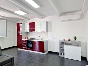 een keuken met rode en witte kasten en een wastafel bij Vertigo in Casoria