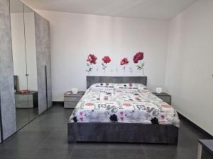 a bedroom with a bed with red flowers on the wall at Vertigo in Casoria +10 photos