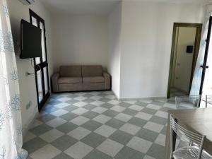 a living room with a couch and a checkerboard floor at Su Coru Budoni in Budoni