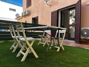a picnic table and chairs on a lawn at Su Coru Budoni in Budoni