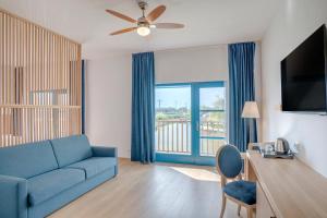 ein Wohnzimmer mit einer blauen Couch und einem großen Fenster in der Unterkunft Gura Portitei Resort in Jurilovca