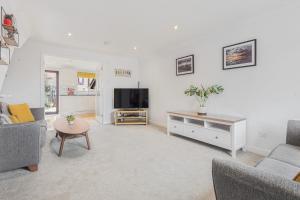 a living room with two couches and a flat screen tv at Quaint house - PARKING GARDEN in Brighton & Hove