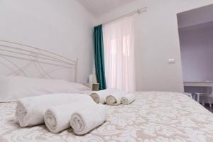 a white bedroom with three towels on a bed at VILLA IRMA in Varigotti
