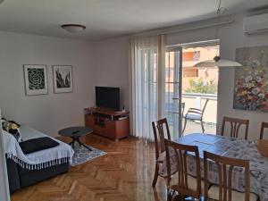 een woonkamer met een tafel en een eetkamer bij Apartments Antica in Rab