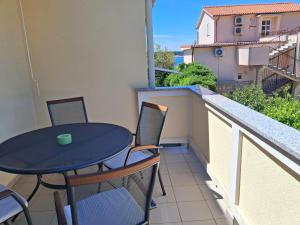 een klein balkon met een tafel en stoelen erop bij Apartments Antica in Rab