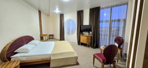 a hotel room with a bed and a television at Wellotel Chornomorsk in Chornomorsk