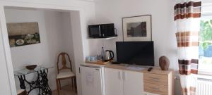 a living room with a tv on top of a cabinet at Schöne Wohnung in Arnsberg mit tollem Ausblick in Arnsberg