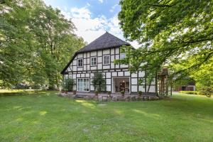 a large house with a green lawn in front of it at Wohnung inmitten Heide und Natur in Soltau
