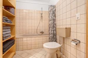 a bathroom with a toilet and a shower at Wohnung inmitten Heide und Natur in Soltau +23 photos