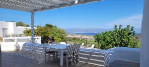 a table and chairs on a patio with a view of the ocean at Villa Mikro Chorio in Kóstos