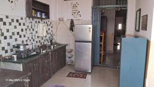 a kitchen with a white refrigerator in a room at Green male rooms in Bhopal