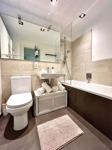 ein Badezimmer mit Toilette, Waschbecken und Badewanne in der Unterkunft Balkon und Eleganz Düsseldorf in Düsseldorf