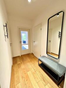 ein Bad mit einem Spiegel und einer Bank in einem Zimmer in der Unterkunft Balkon und Eleganz Düsseldorf in Düsseldorf