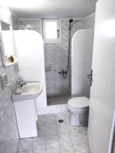 a white bathroom with a toilet and a sink at Hilltop Serenity Villa in Imerovigli +24 photos