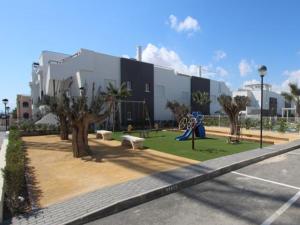 a park with benches and trees in front of a building at Vista Bella in Torrevieja