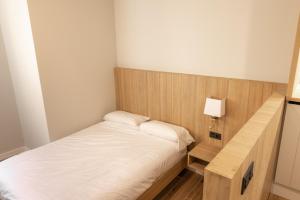 a small bedroom with a bed with a wooden headboard at E16 - Estudio La Orotava in La Orotava