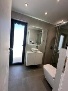 アテネにあるPenthouse with sea viewの白いトイレと洗面台のあるバスルーム +16枚の写真