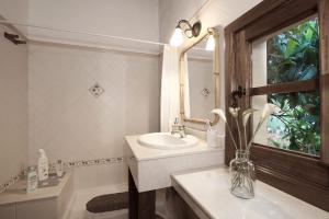 a bathroom with a sink and a vase of flowers at Fontanales Pelibuey by Villas Rivero in Moya +18 photos