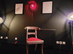 a wooden chair with a red seat in a room at Gîte romantique Le GLAMOUR in Mazé +2 photos