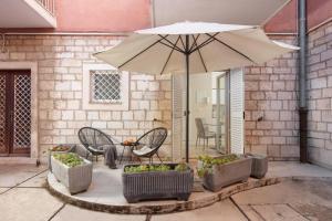 a patio with an umbrella and chairs and a table at Luxury 4 star apartment in the Old Town Zadar in Zadar