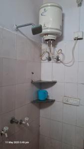 a bathroom with a shower with a light on the wall at Green male rooms in Bhopal