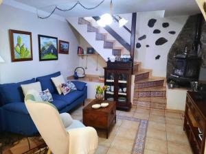 a living room with a blue couch and stairs at Casa Rural Sanjora in Valverde