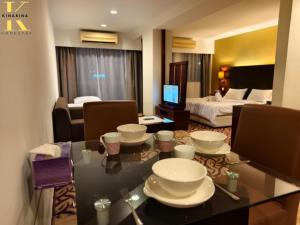 a hotel room with a dining table and a bedroom at South China Sea Place by Kinabina Homestay in Kota Kinabalu