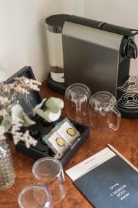 einen Tisch mit Weingläsern und eine Kaffeemaschine in der Unterkunft L'Absinthe Hôtel in Honfleur + 57 Fotos