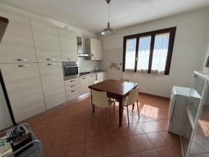 a kitchen with a wooden table and chairs in it at Da Alice in Montale +13 photos