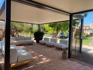 a pavilion with white couches and chairs on a patio at Le Stanze del Convento San Giuseppe in Cagliari
