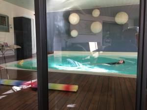 a person laying in a swimming pool at chambre d hôtes les trois châteaux in Notre-Dame-de-Riez