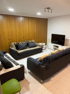 Una sala de estar con dos sofás y un televisor de pantalla plana. en San Jose Luminoso, en Algemesí
