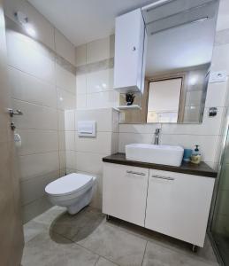 a white bathroom with a toilet and a sink at Studio Jadro in Selce